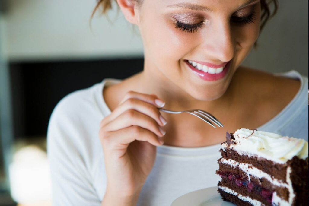 אישה נהנית מעוגת שוקולד ללא סוכר שהוכנה עם אריתריטול